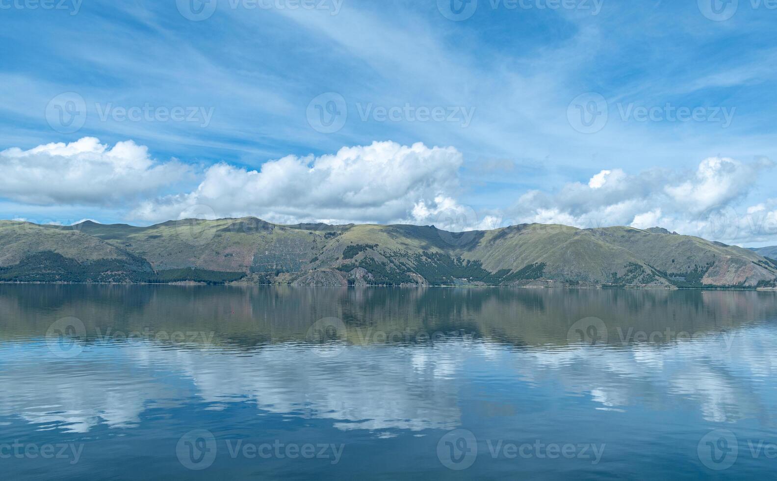 lagoon in the foreground with mountains with forests in the background and cloudy sky in Acomayo, Cusco, Per photo
