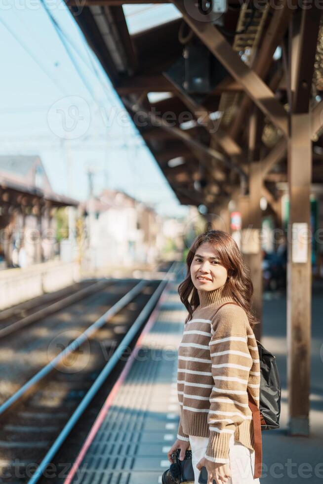 Woman tourist waiting train and Visiting in Kamakura, Kanagawa, Japan. happy Traveler sightseeing Kamakura train station. Landmark and popular for tourists attraction near Tokyo. Travel and Vacation photo