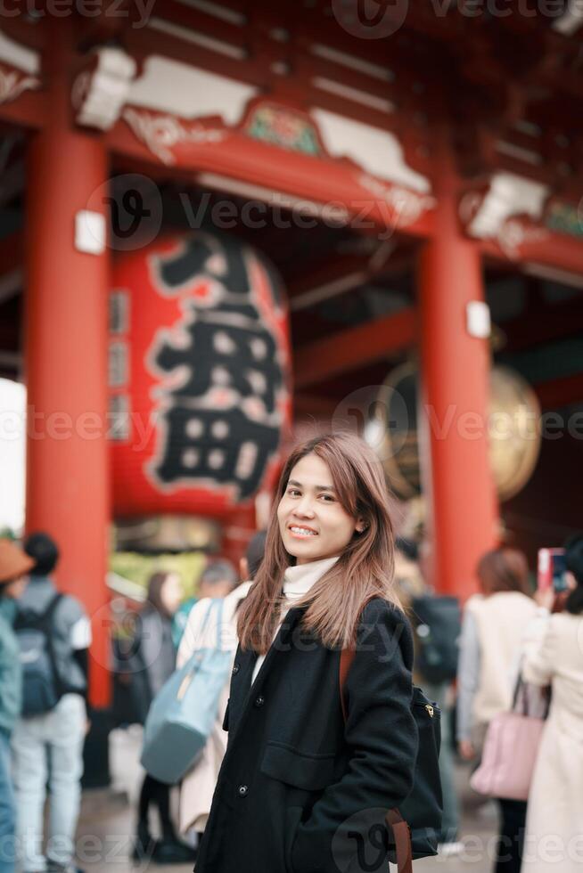 Tourist woman visit Sensoji Temple or Asakusa Kannon Temple is a Buddhist temple located in Asakusa, Tokyo Japan. Japanese sentence on red lantern means Thunder gate. photo