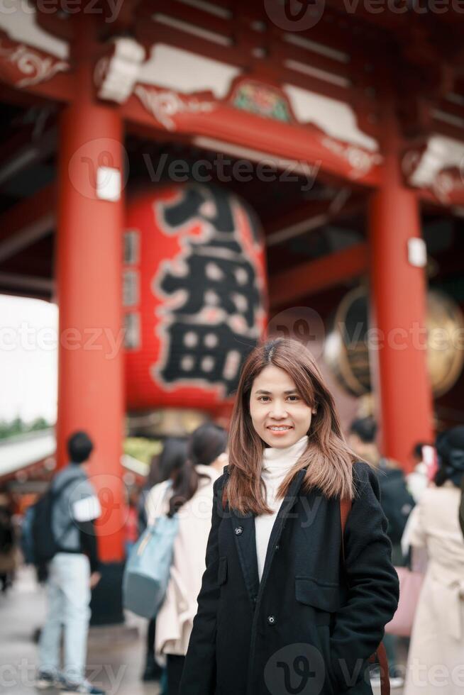 Tourist woman visit Sensoji Temple or Asakusa Kannon Temple is a Buddhist temple located in Asakusa, Tokyo Japan. Japanese sentence on red lantern means Thunder gate. photo