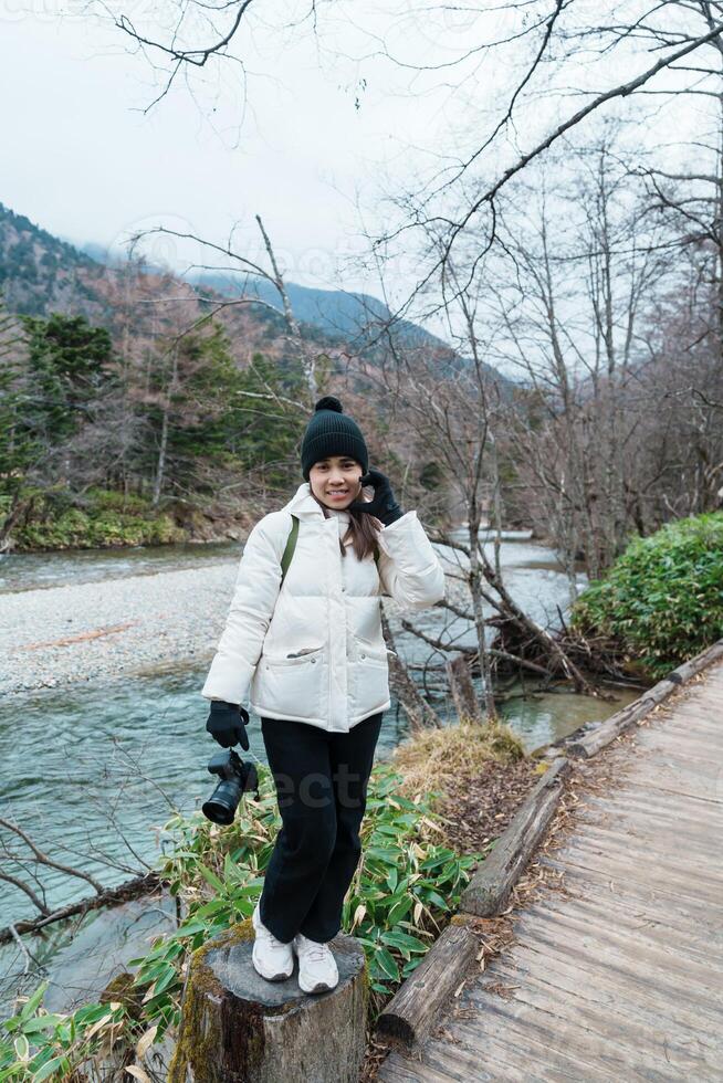 Woman tourist travel Kamikochi National Park, happy Traveler sightseeing Azusa river with mountain, Nagano Prefecture, Japan. Landmark for tourists attraction. Japan Travel, Destination and Vacation photo