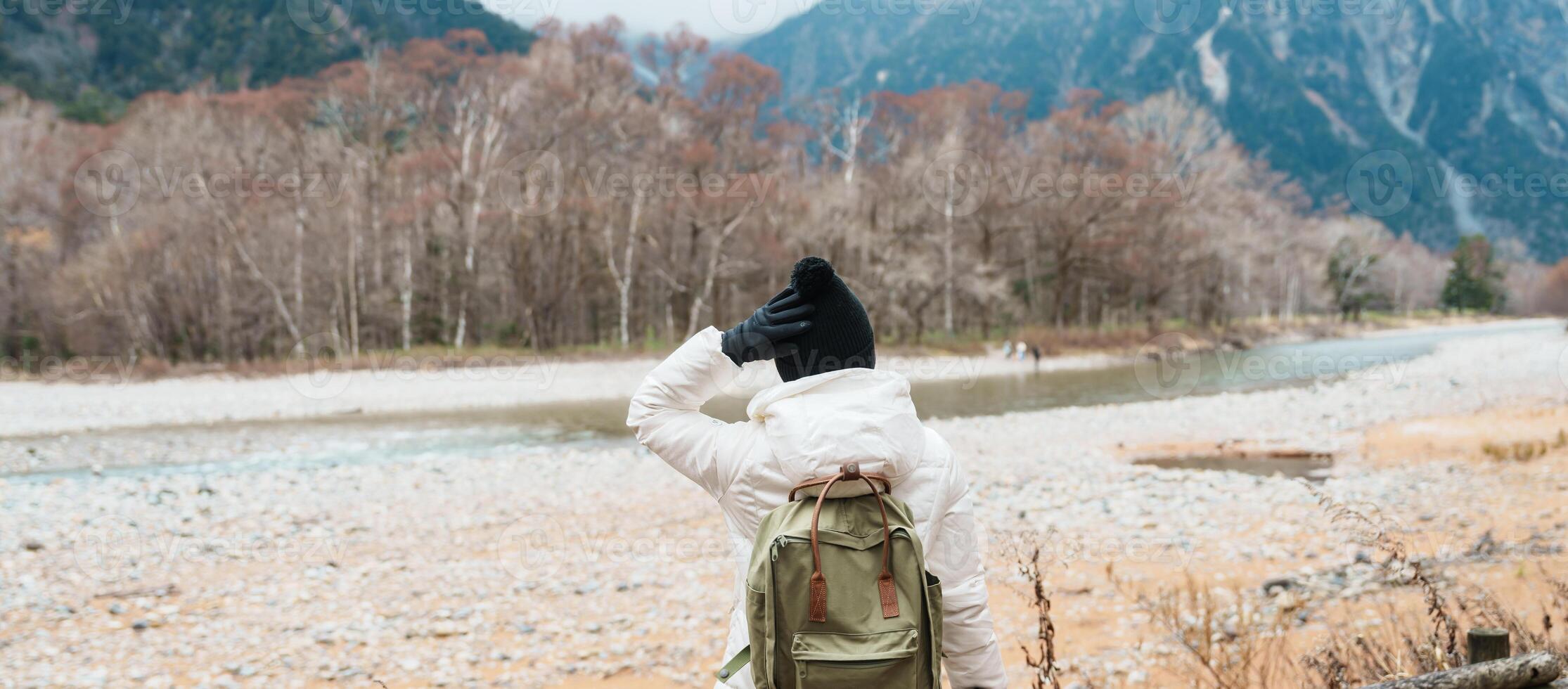 Woman tourist travel Kamikochi National Park, happy Traveler sightseeing Azusa river with mountain, Nagano Prefecture, Japan. Landmark for tourists attraction. Japan Travel, Destination and Vacation photo