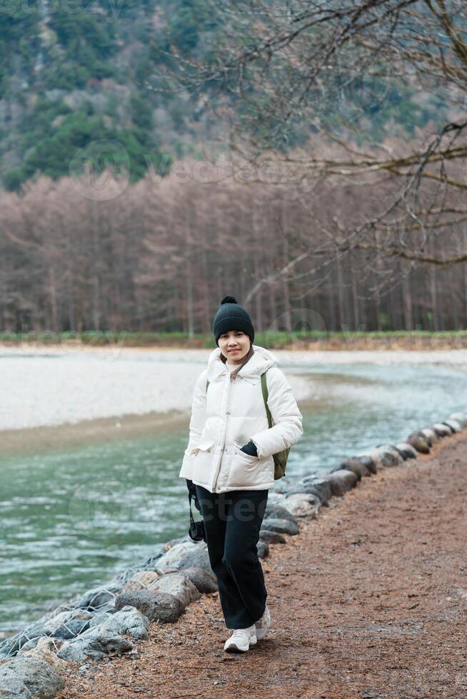 Woman tourist travel Kamikochi National Park, happy Traveler sightseeing Azusa river with mountain, Nagano Prefecture, Japan. Landmark for tourists attraction. Japan Travel, Destination and Vacation photo