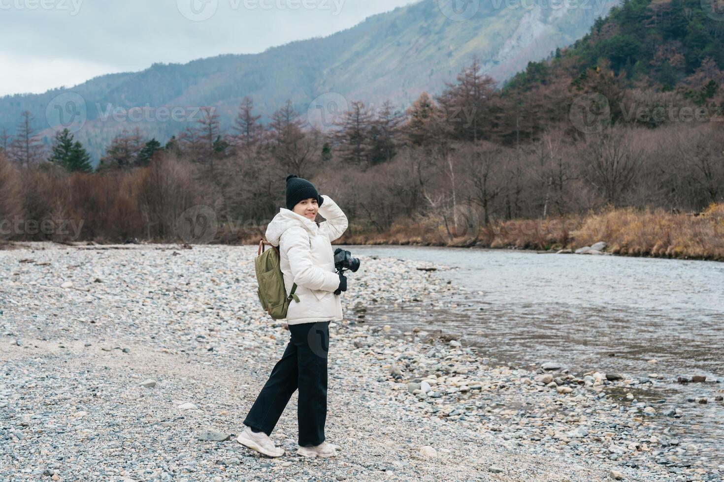 Woman tourist travel Kamikochi National Park, happy Traveler sightseeing Azusa river with mountain, Nagano Prefecture, Japan. Landmark for tourists attraction. Japan Travel, Destination and Vacation photo