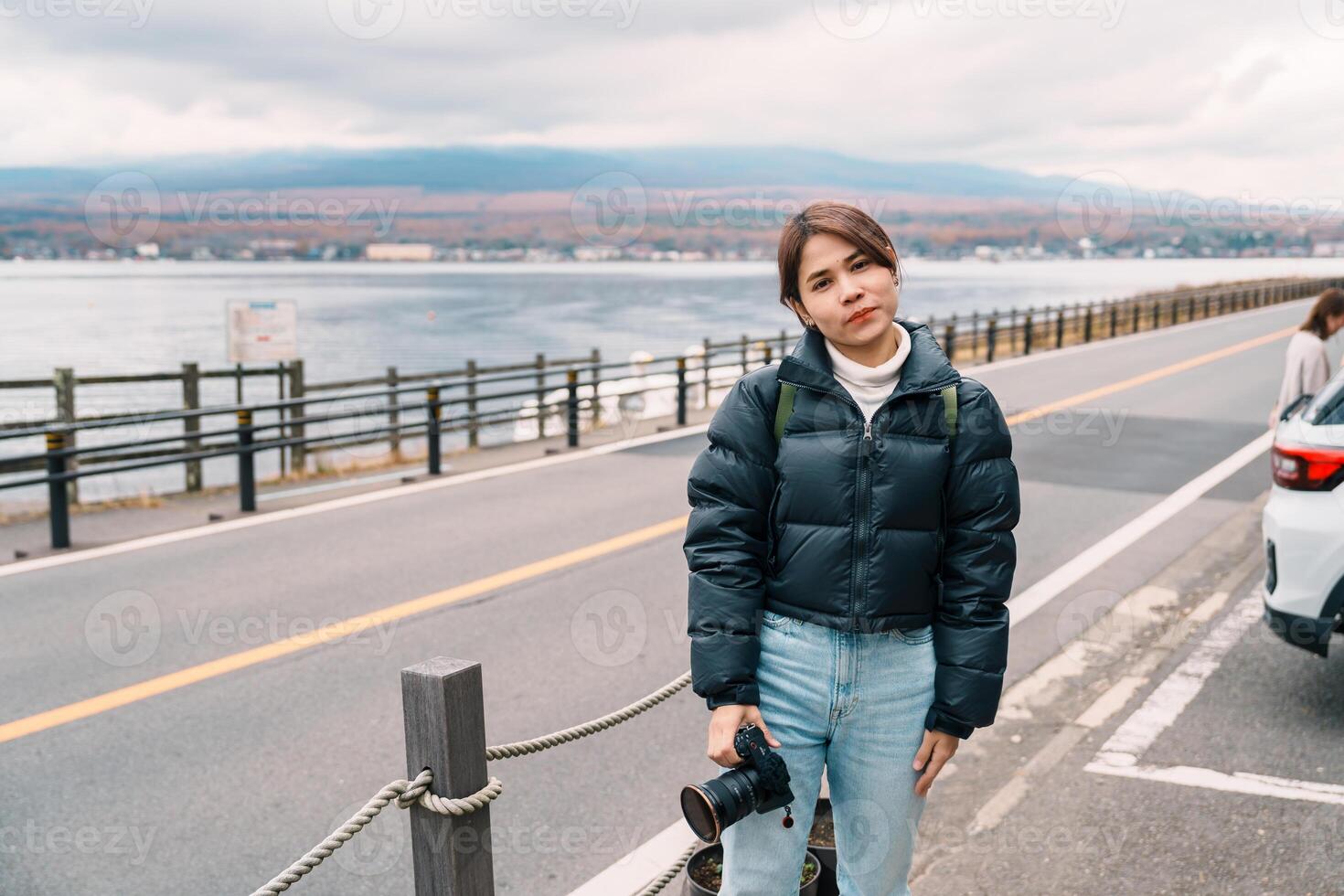 Woman tourist with Mt Fuji at Lake Yamanaka, happy Traveler sightseeing Mount Fuji in Yamanakako village, Yamanashi, Japan. Landmark for tourists attraction. Japan Travel, Destination and Vacation photo
