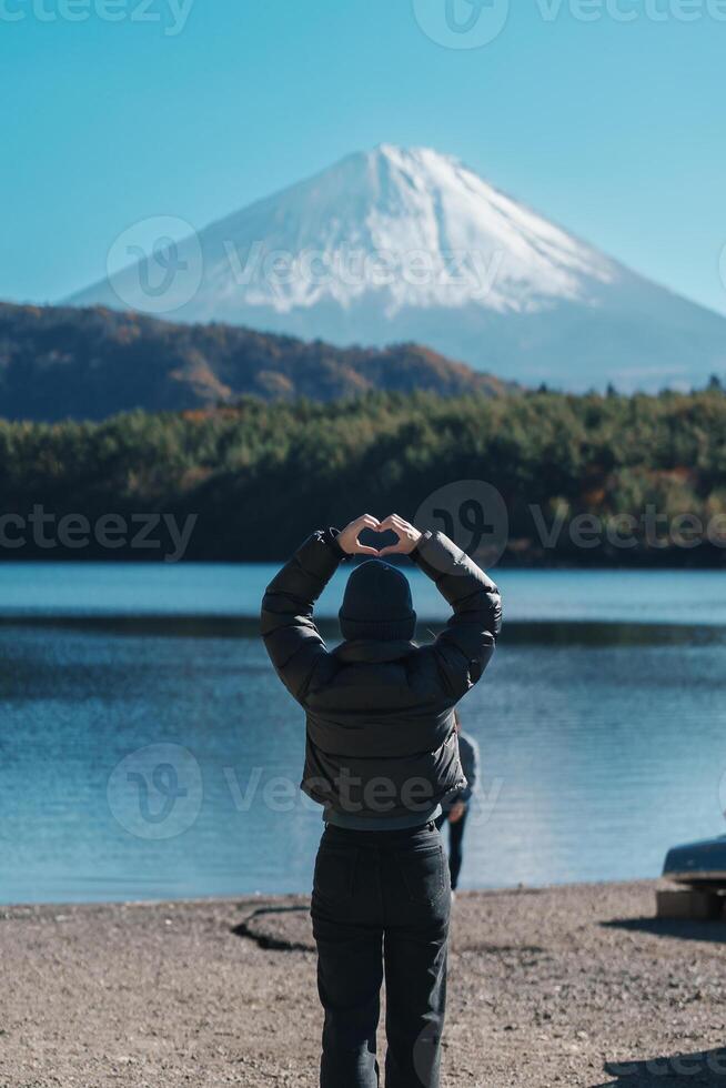 Woman tourist enjoy with Fuji Mountain at Lake Saiko, happy Traveler sightseeing Mount Fuji and road trip Fuji Five Lakes. Landmark for tourists attraction. Japan Travel, Destination and Vacation photo