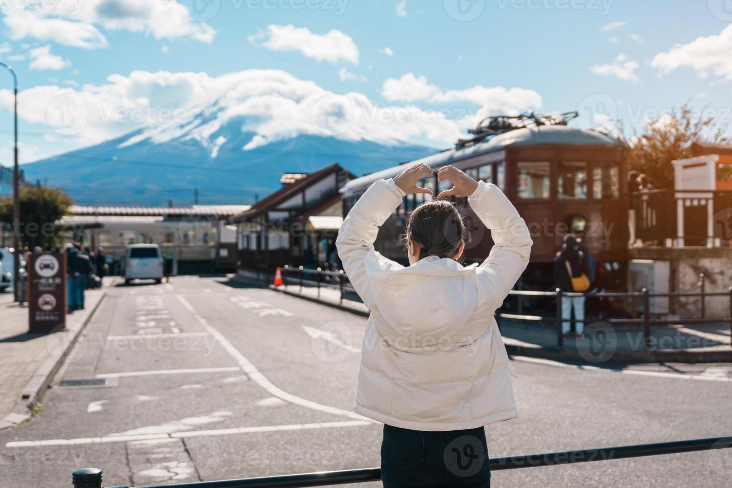 Woman tourist with Fuji Mountain at Kawaguchiko train station, happy Traveler sightseeing Mount Fuji in Yamanashi, Japan. Landmark for tourists attraction. Japan Travel, Destination and Vacation photo