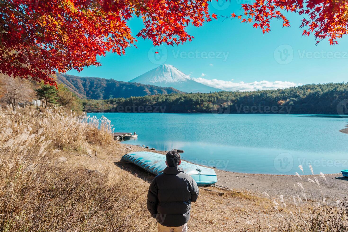 man tourist with Fuji Mountain at Lake Saiko in Autumn season, happy Traveler travel Mount Fuji, Yamanashi, Japan. Landmark for tourists attraction. Japan Travel, Destination and Vacation photo