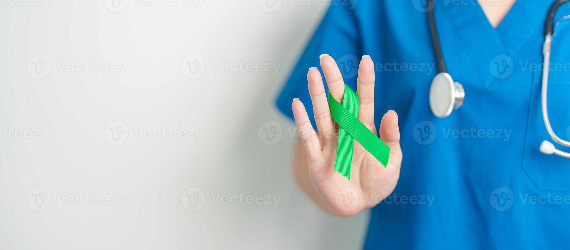 Doctor with green Ribbon for world Lymphoma Awareness September month, world Mental Health Day, Liver, Gallbladders, bile duct, cervical, kidney Cancer. Healthcare and world cancer day concept photo