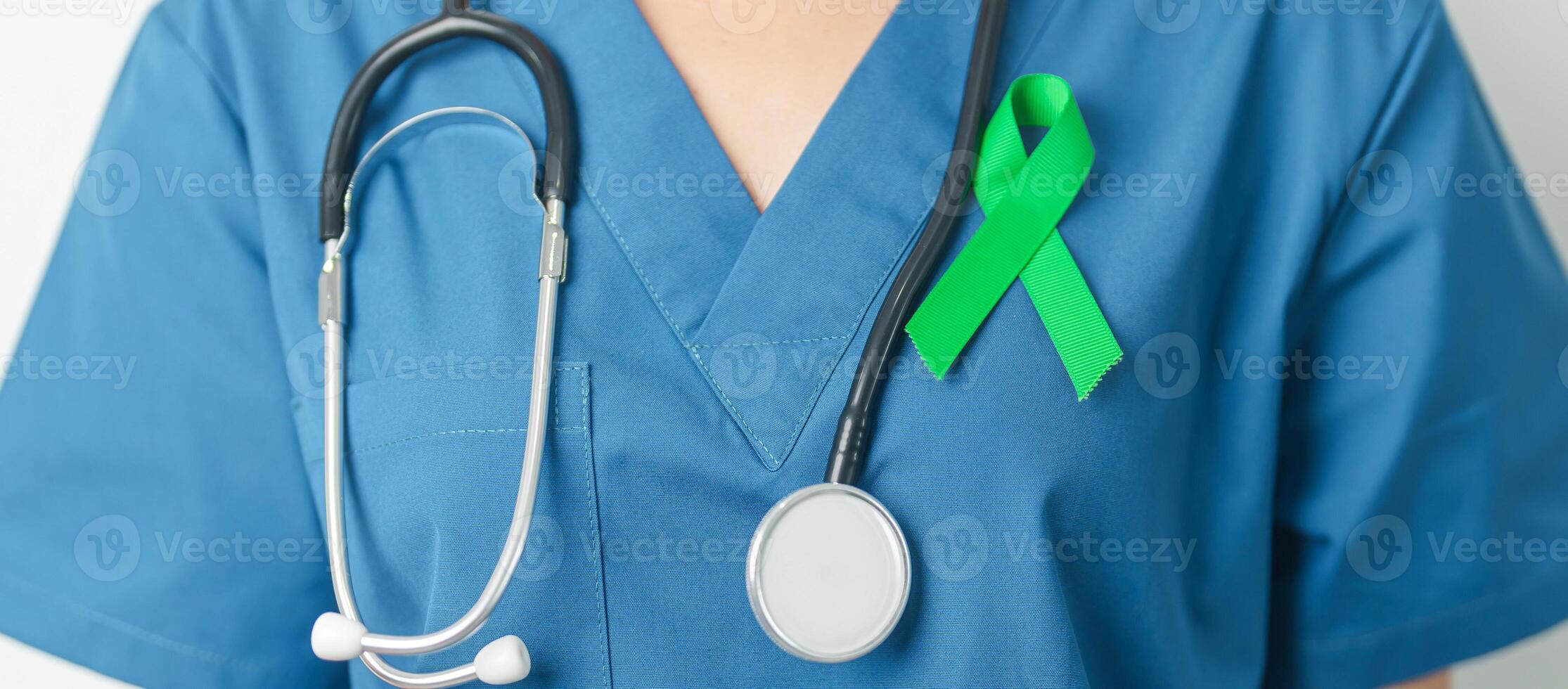 Doctor with green Ribbon for world Lymphoma Awareness September month, world Mental Health Day, Liver, Gallbladders, bile duct, cervical, kidney Cancer. Healthcare and world cancer day concept photo