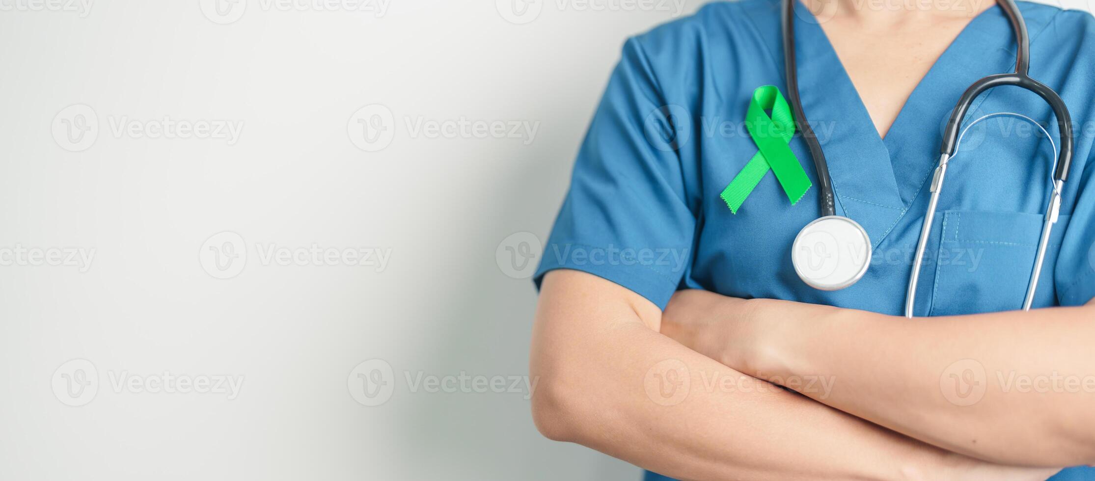 Doctor with green Ribbon for world Lymphoma Awareness September month, world Mental Health Day, Liver, Gallbladders, bile duct, cervical, kidney Cancer. Healthcare and world cancer day concept photo