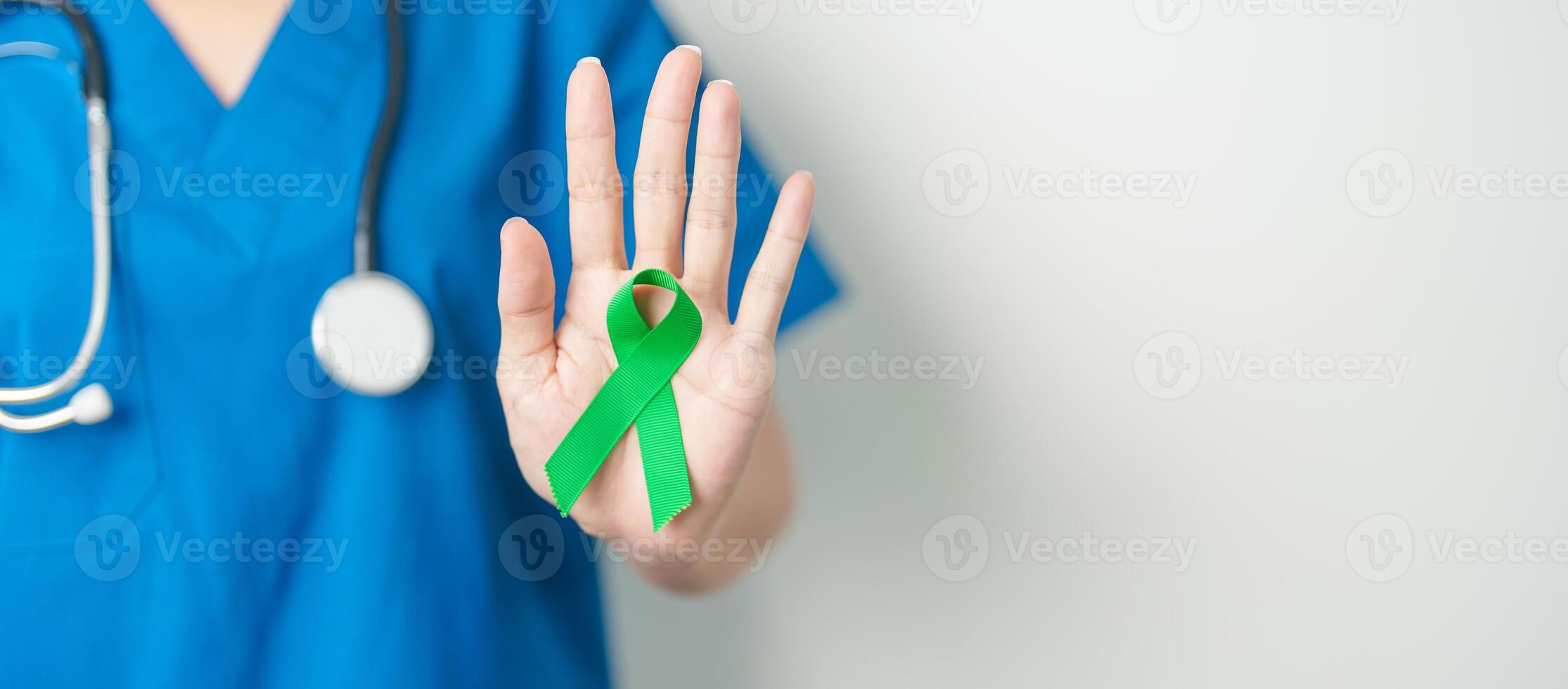 Doctor with green Ribbon for world Lymphoma Awareness September month, world Mental Health Day, Liver, Gallbladders, bile duct, cervical, kidney Cancer. Healthcare and world cancer day concept photo