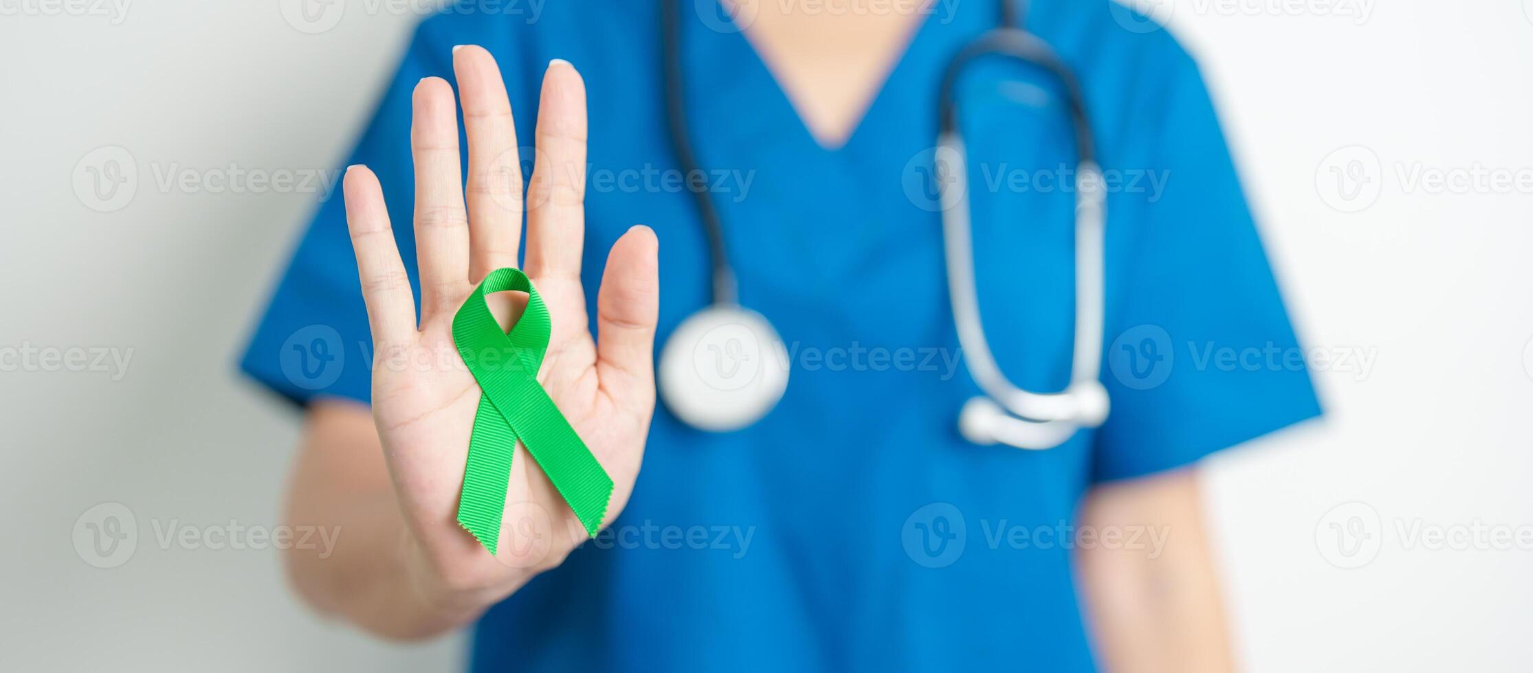 Doctor with green Ribbon for world Lymphoma Awareness September month, world Mental Health Day, Liver, Gallbladders, bile duct, cervical, kidney Cancer. Healthcare and world cancer day concept photo