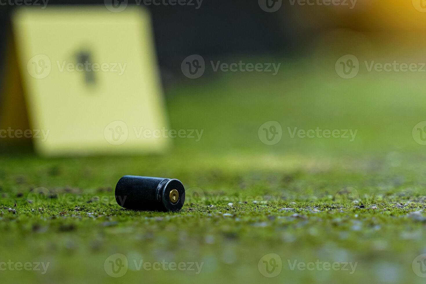 Bullet casings fall on cement floor and blurred background of evidence number sign at shooting scene. Concept of investigation, forensics, evidence, forensic science. photo