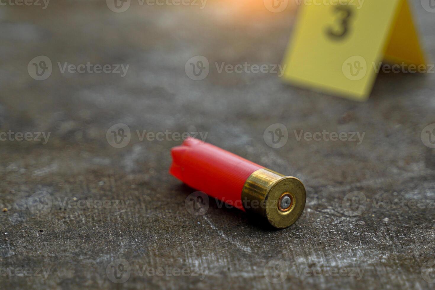 Bullet casings fall on cement floor and blurred background of evidence number sign at shooting scene. Concept of investigation, forensics, evidence, forensic science. photo