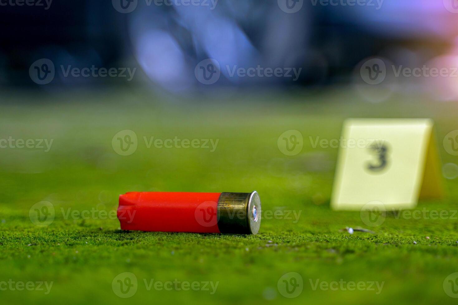 Bullet casings fell on the moss growing on the cement floor and blurry background of the evidence number plate at the scene and the car belonging to the culprit. Concept of investigation photo