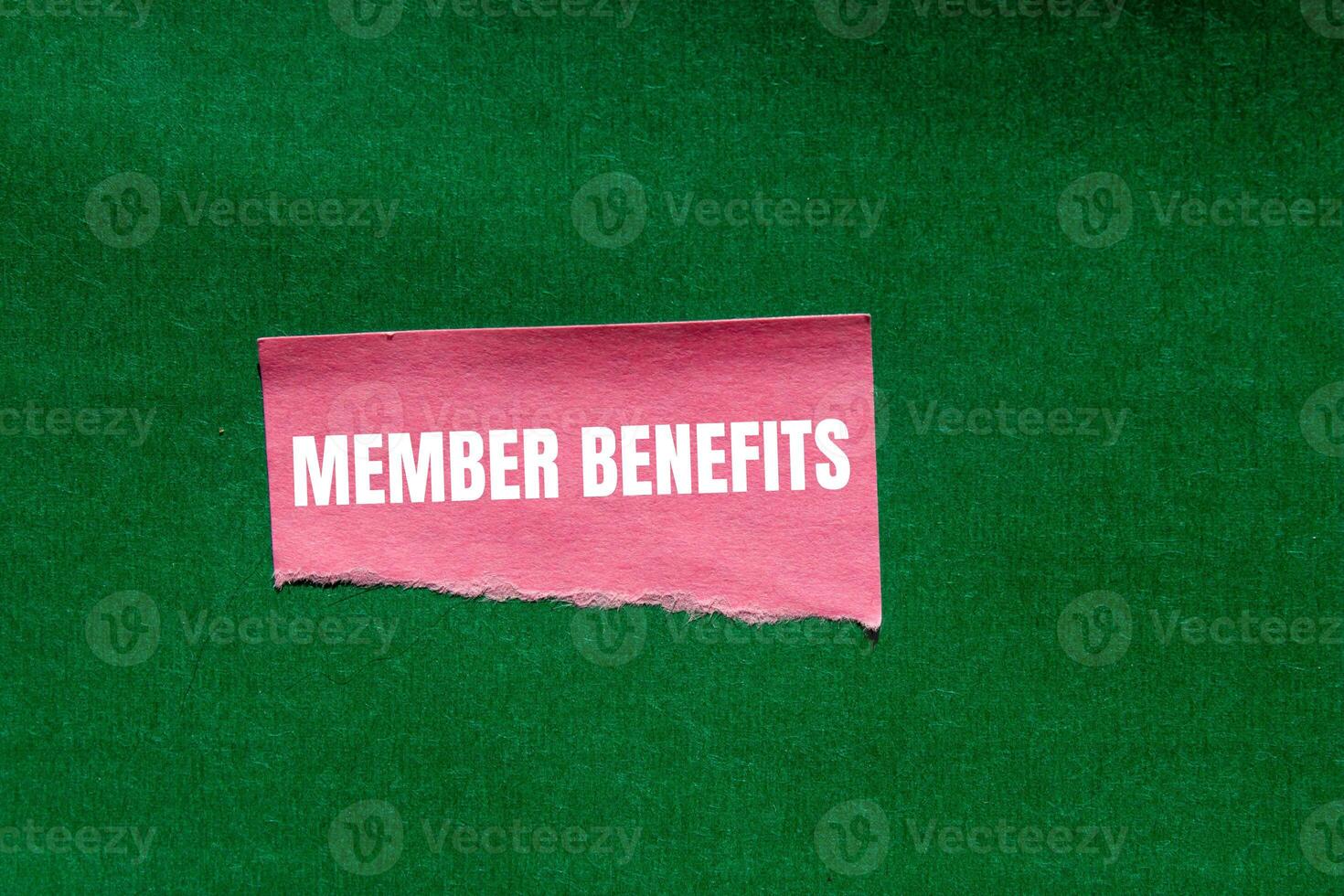 Member benefits message written on ripped torn pink paper piece on green background. Conceptual member benefits symbol. Copy space. photo