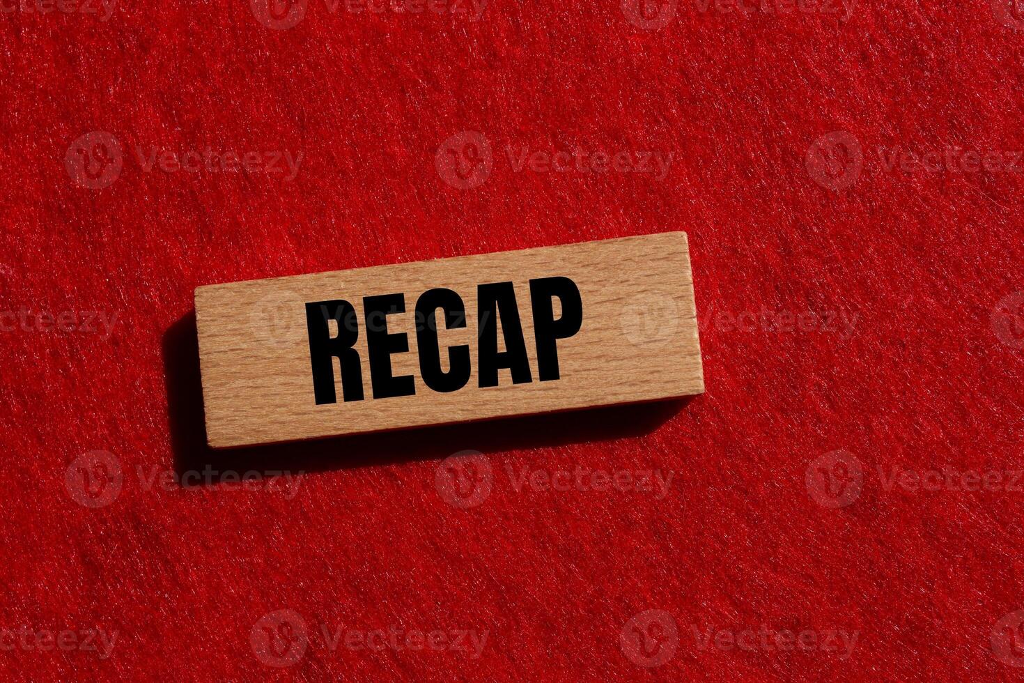 Recap word written on wooden block with red background. Conceptual recap word symbol. Copy space. photo
