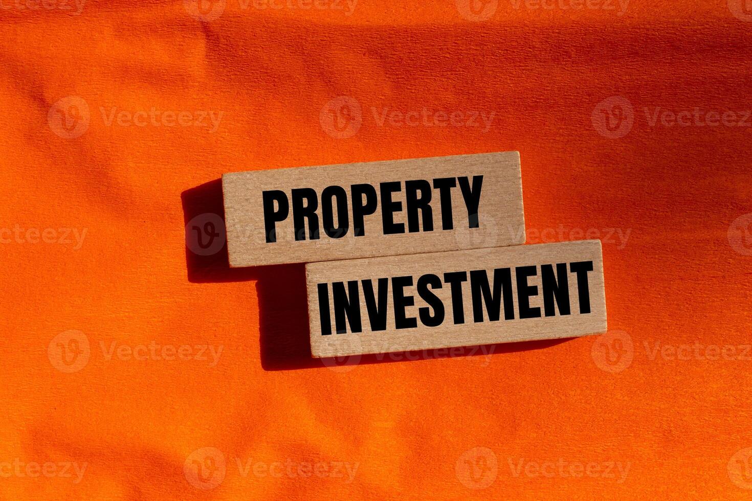 Property investment message written on wooden blocks with orange background. Conceptual property investment symbol. Copy space. photo