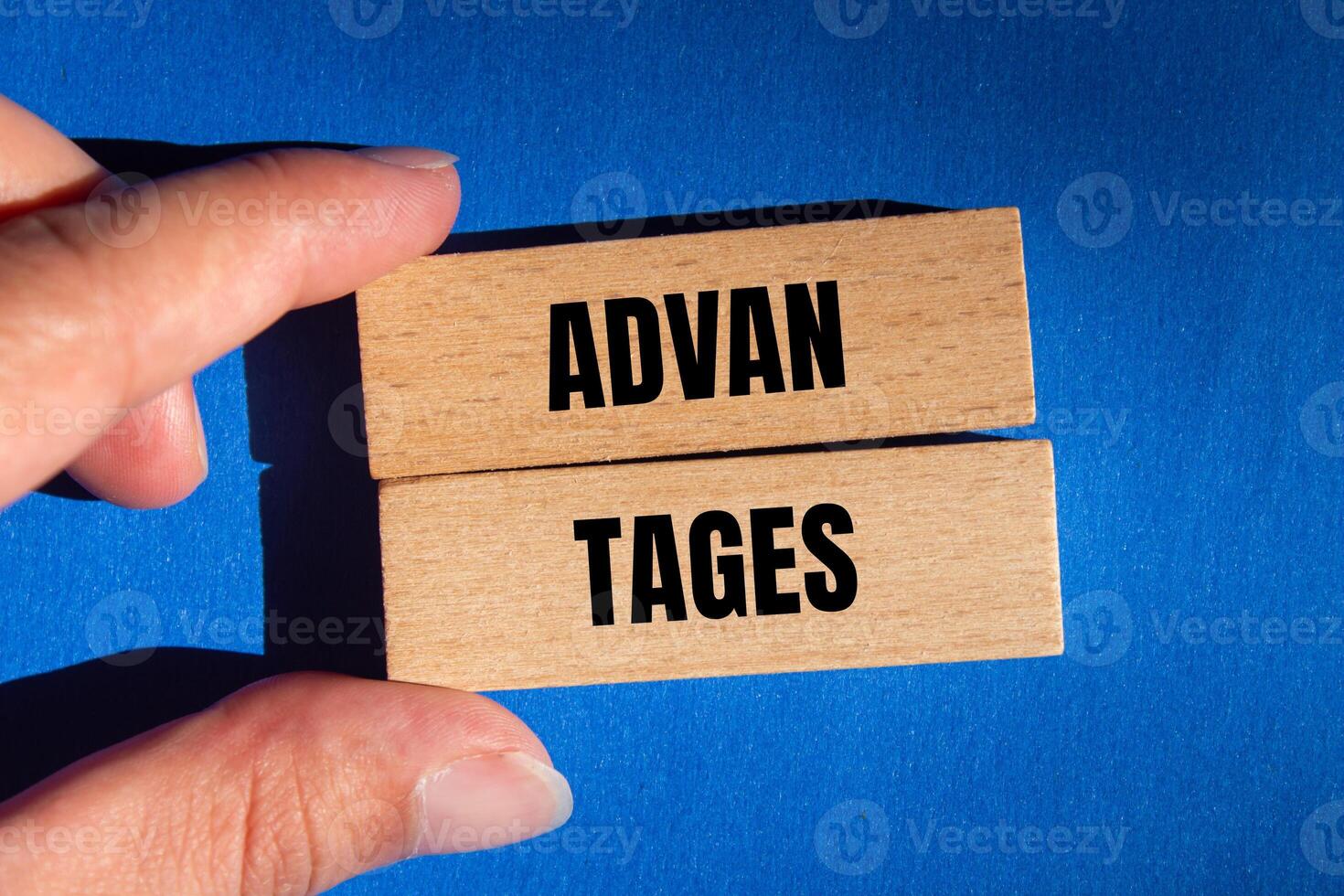 Advantages message written on wooden blocks with blue background. Conceptual advantages symbol. Copy space. photo