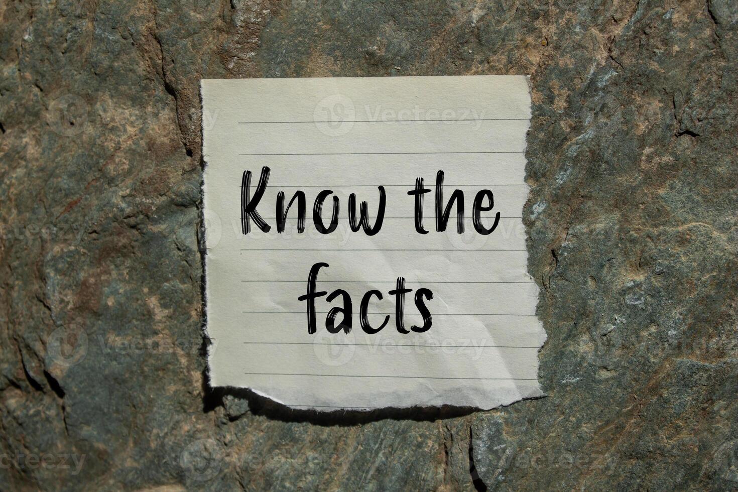 Know the facts message written on ripped torn paper piece with stone background. Conceptual know the facts symbol. Copy space. photo