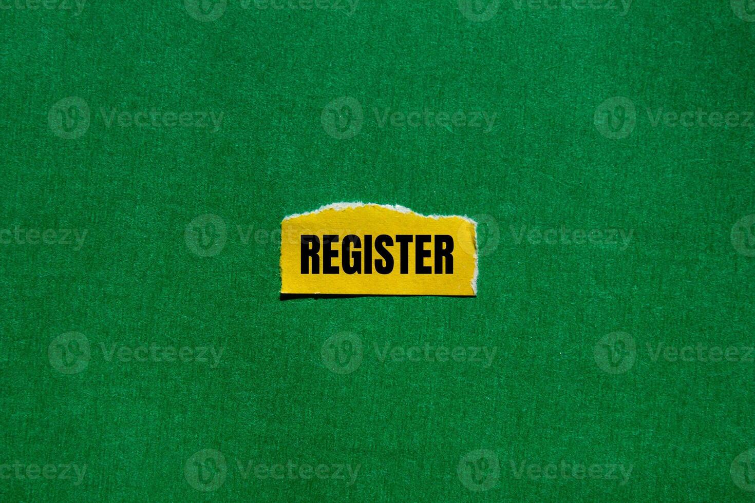 Register message written on ripped torn yellow paper piece with green background. Conceptual register symbol. Copy space. photo