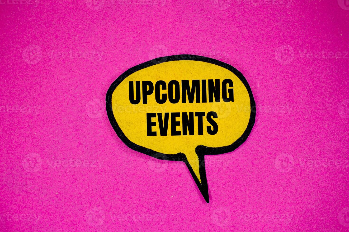 Upcoming events message written on yellow paper speech bubble with pink background. Conceptual upcoming events symbol. Copy space. photo