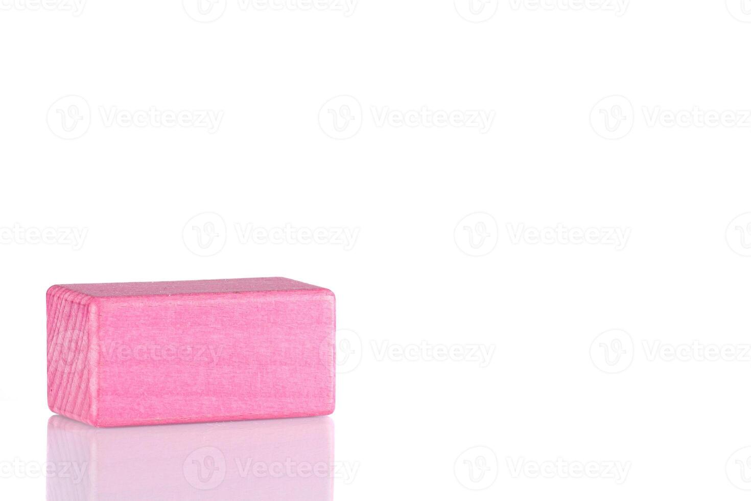 Wooden cube of pink color on a white background photo