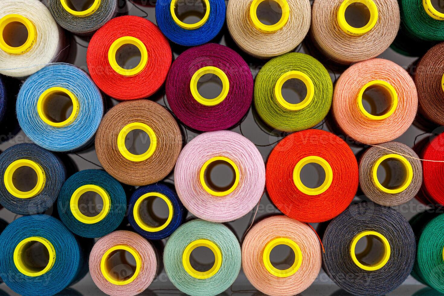 set of multi-colored spools of thread for sewing photo
