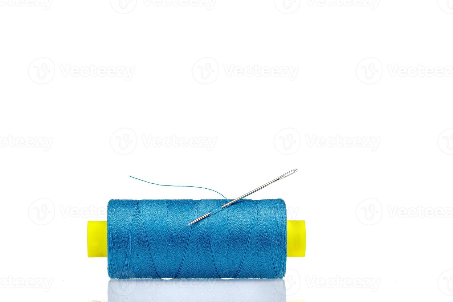 Macro skein of blue thread with a needle on a white background photo