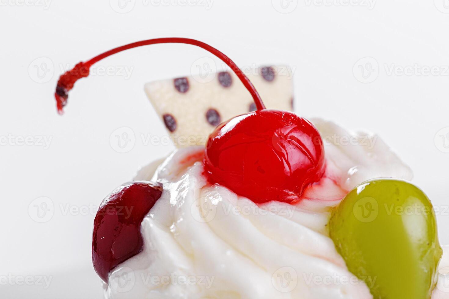 Beautiful cream cakes with cherries and grapes on a plate on a white background photo