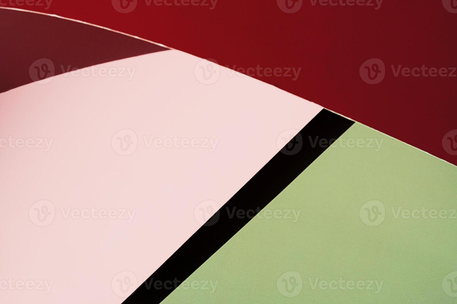 Close up of curved red and pink paper against green background. photo