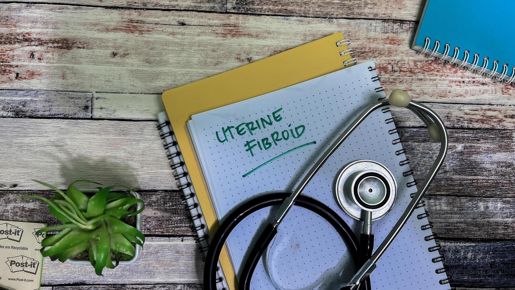 Concept of Uterine Fibroid write on book isolated on Wooden Table. photo