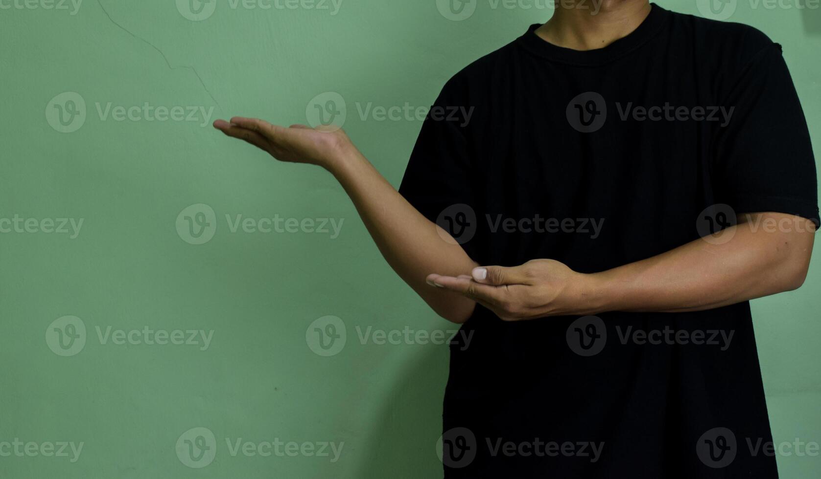 Young man pointing at copy space, showing and advertising empty space photo