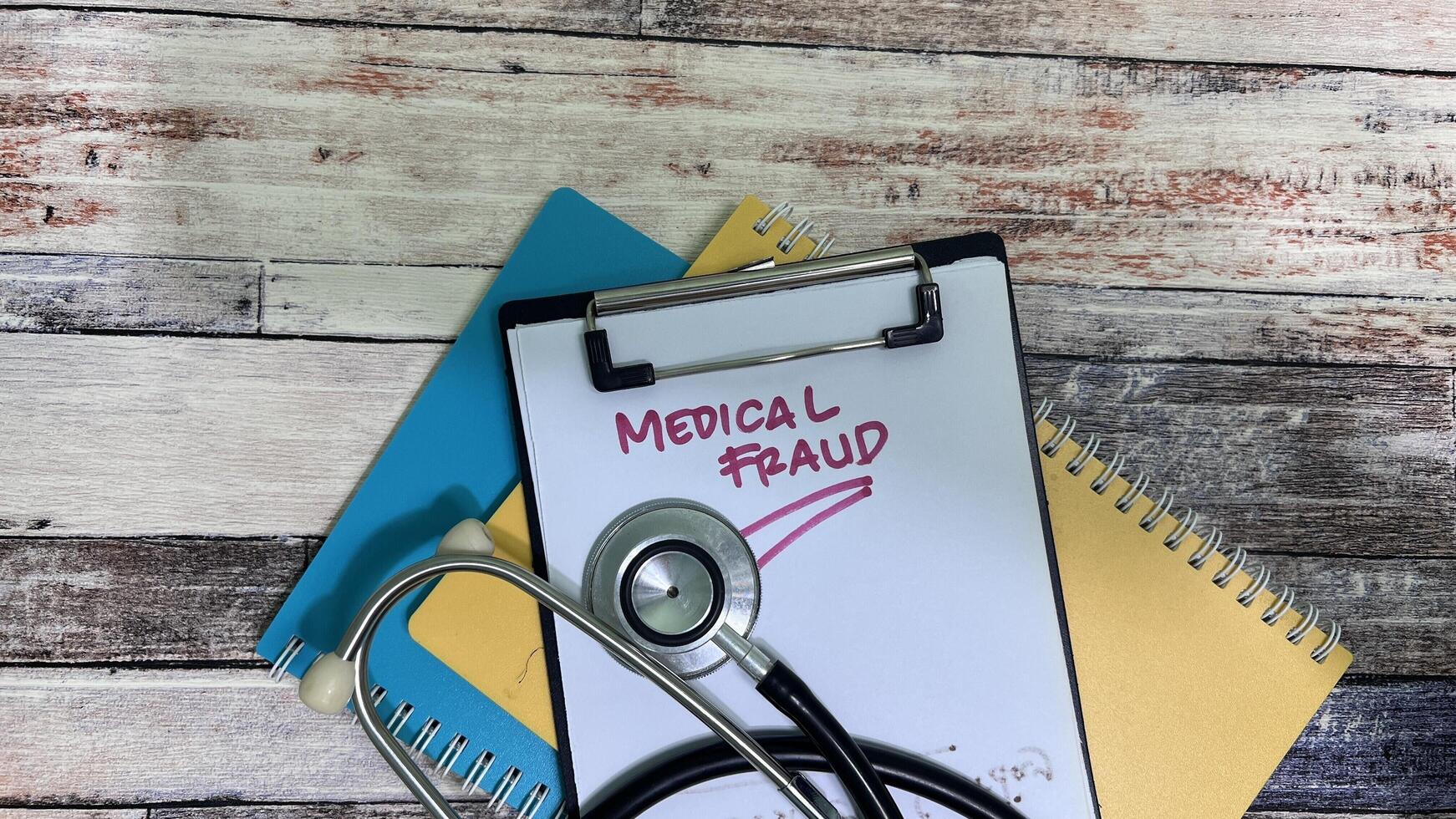 Concept of Medical Fraud write on paperwork isolated on wooden background. photo