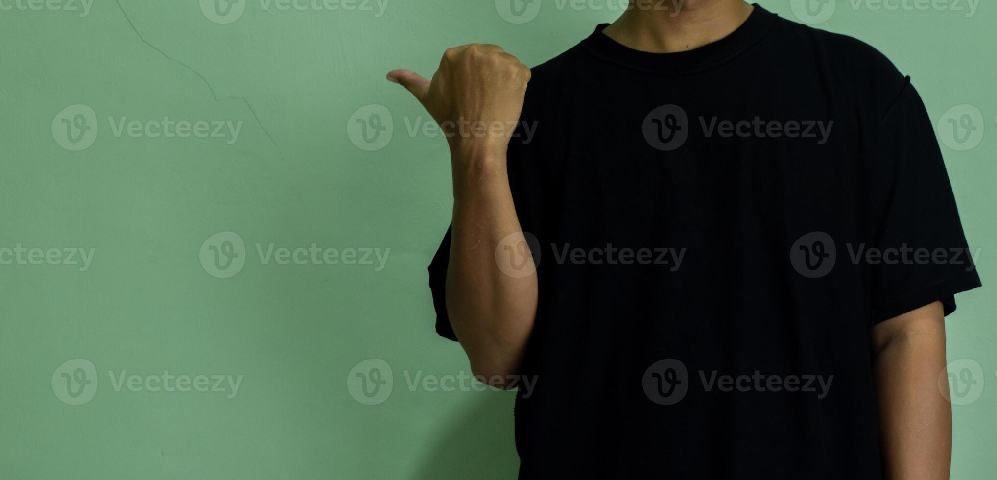 Young man pointing at copy space, showing and advertising empty space photo