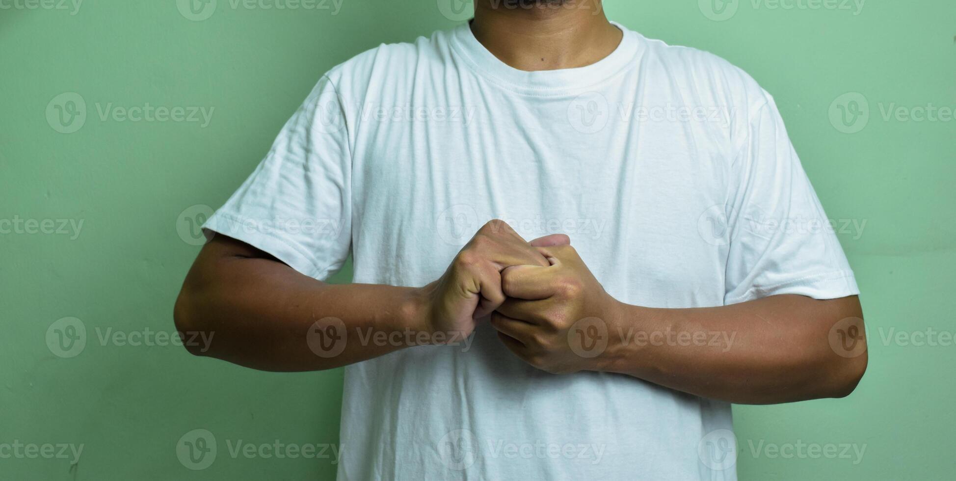 man cracking his knuckles on green background photo