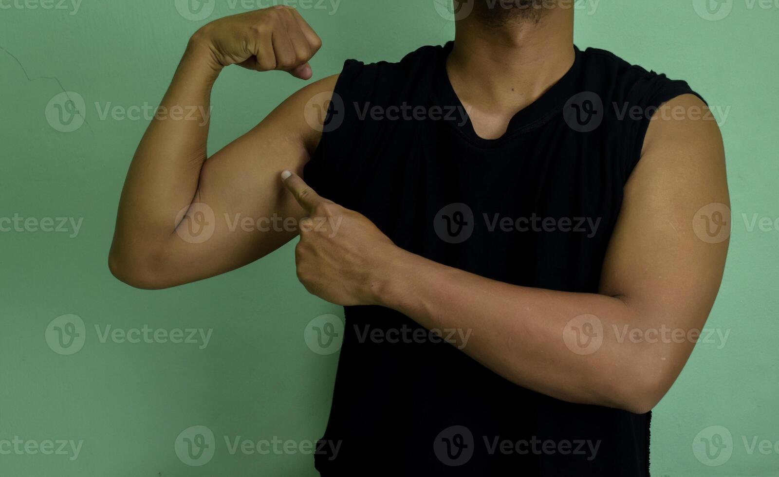 I am strong and powerfull. Potrait of confident successful young man showing biceps photo