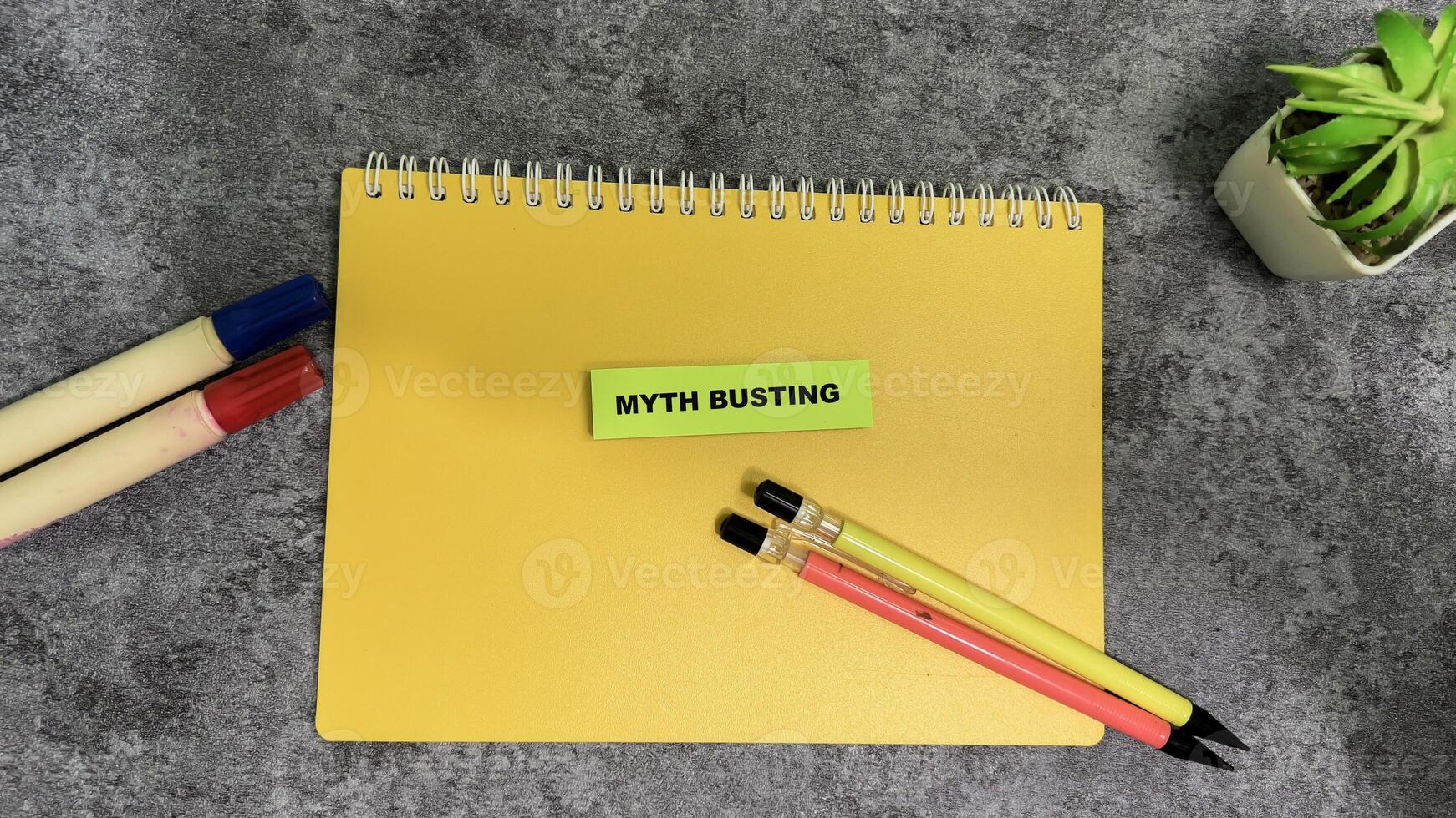 Concept of Myth Busting write on sticky notes isolated on Wooden Table. photo