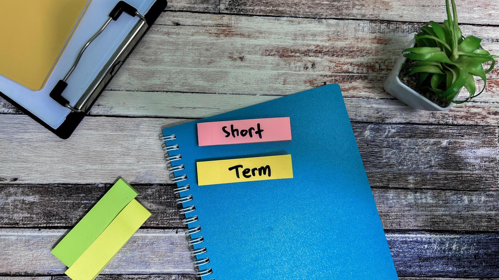 Concept of Short Term write on sticky notes isolated on Wooden Table. photo