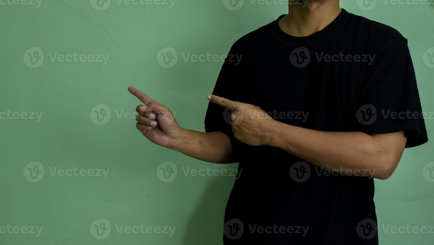 Young man pointing at copy space, showing and advertising empty space photo