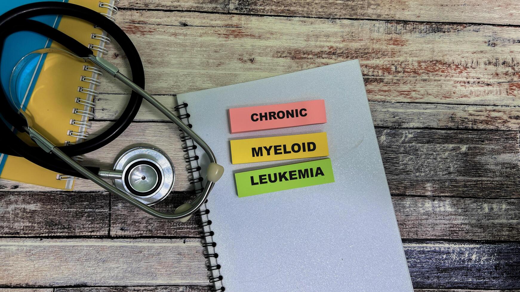 Concept of Chronic Myeloid Leukemia write on sticky notes isolated on Wooden Table. photo