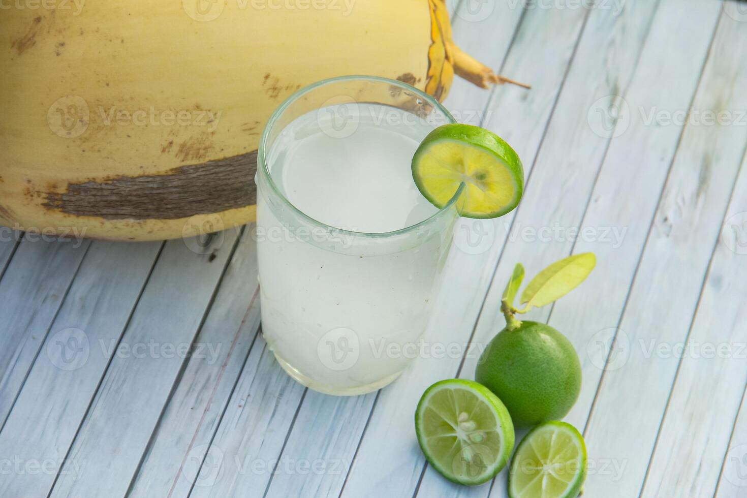 Fresh coconut water from yellow coconuts added with lime juice photo