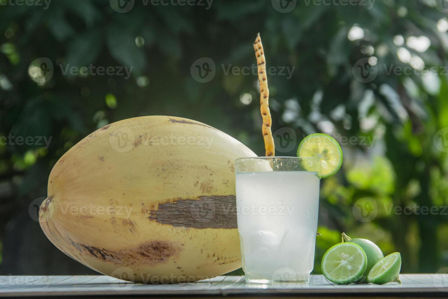 Fresh coconut water from yellow coconuts added with lime juice photo