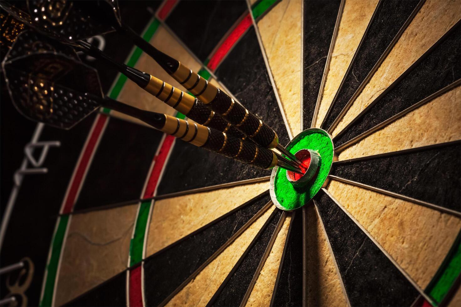 Three darts in bull's eye close up photo