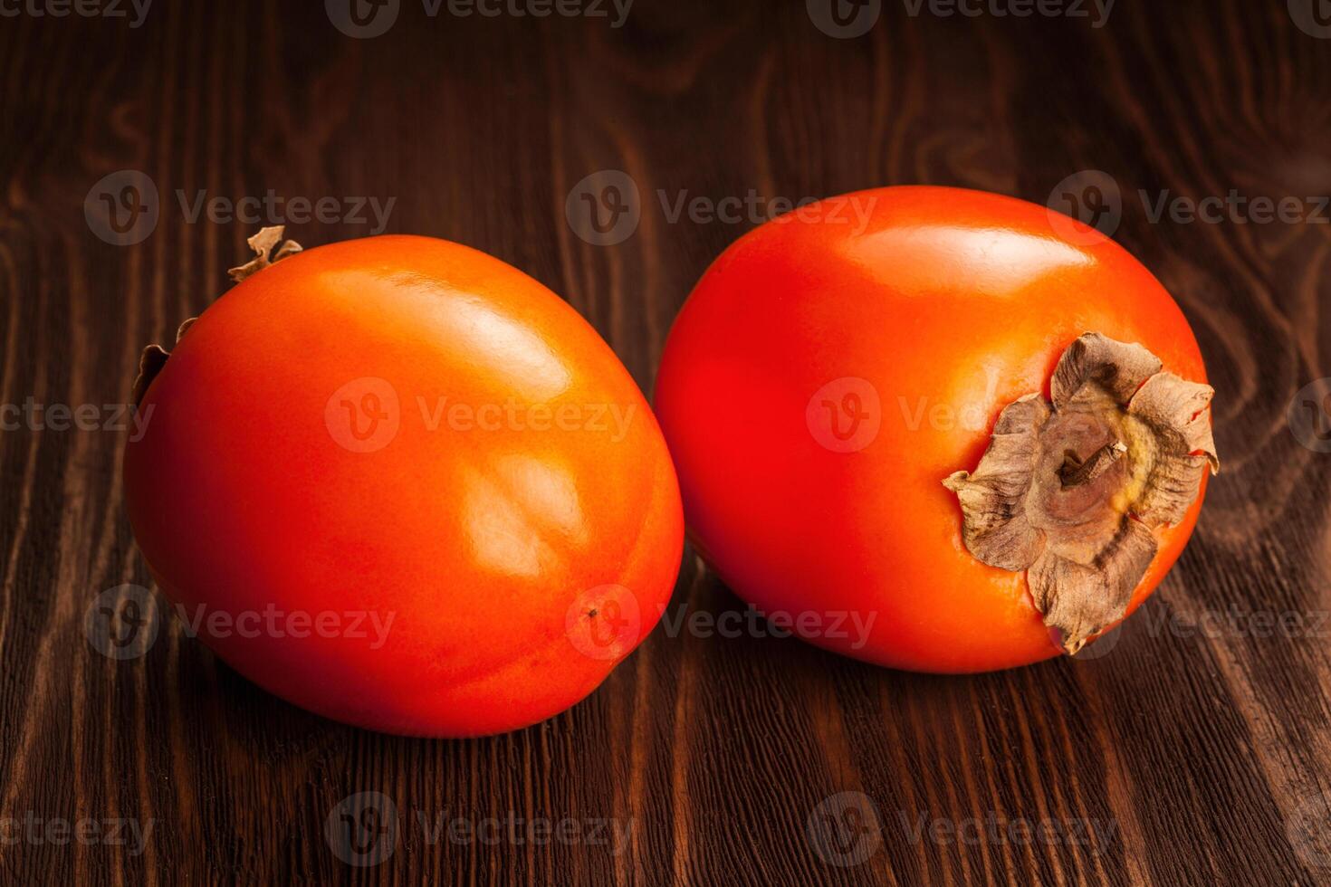 Persimmon on wooden background photo