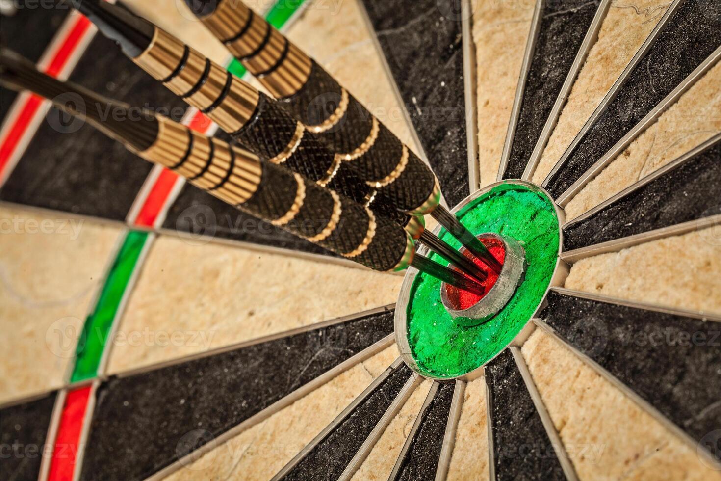 Three darts in bull's eye close up photo