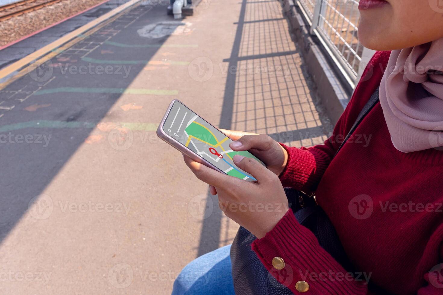 An Asian woman wearing hijab using a map application in photo