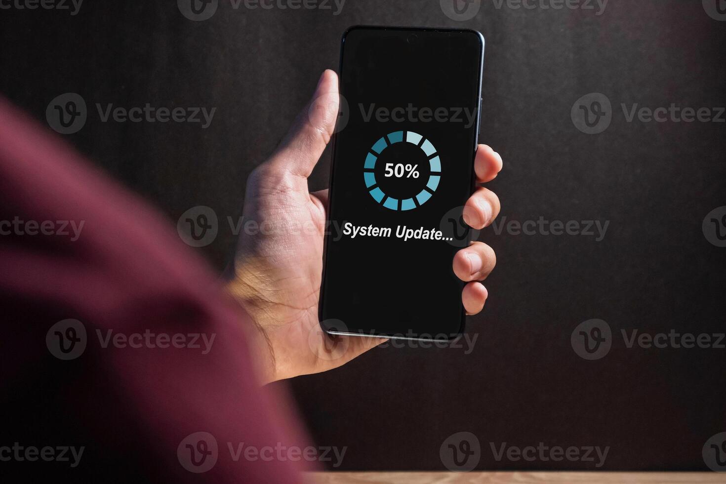 Hand holding a smartphone with software system or application update process on screen photo