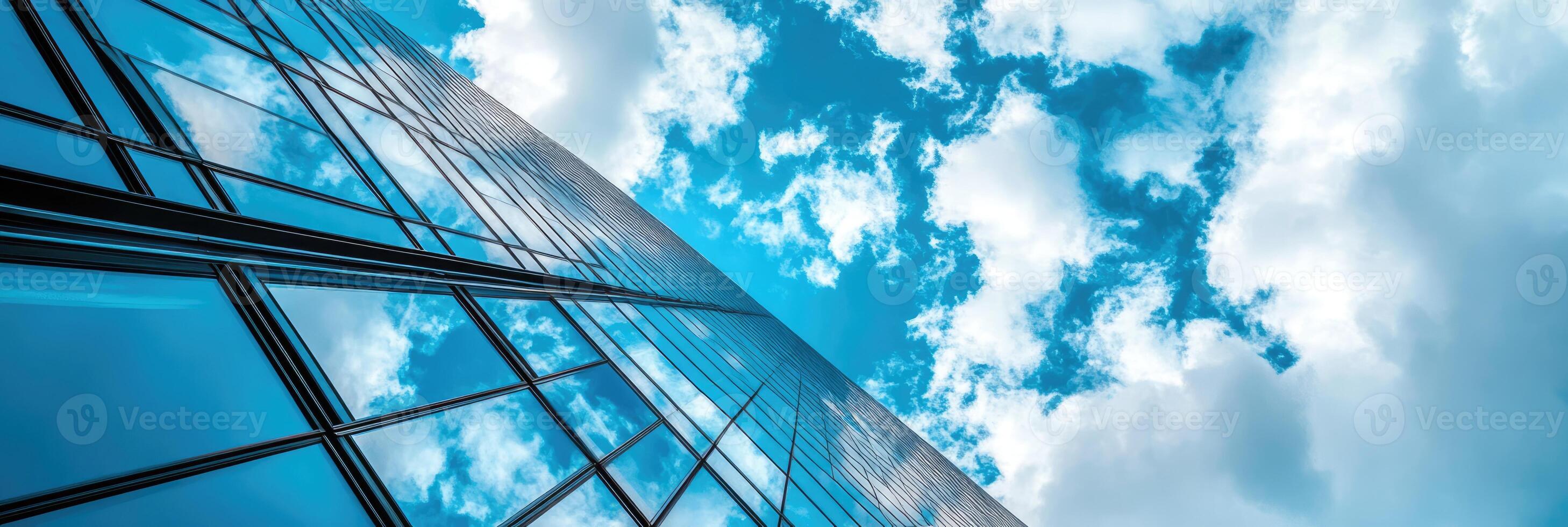 Low angle view of skyscraper with glass windows and blue sky background for business, trade and finance concept photo